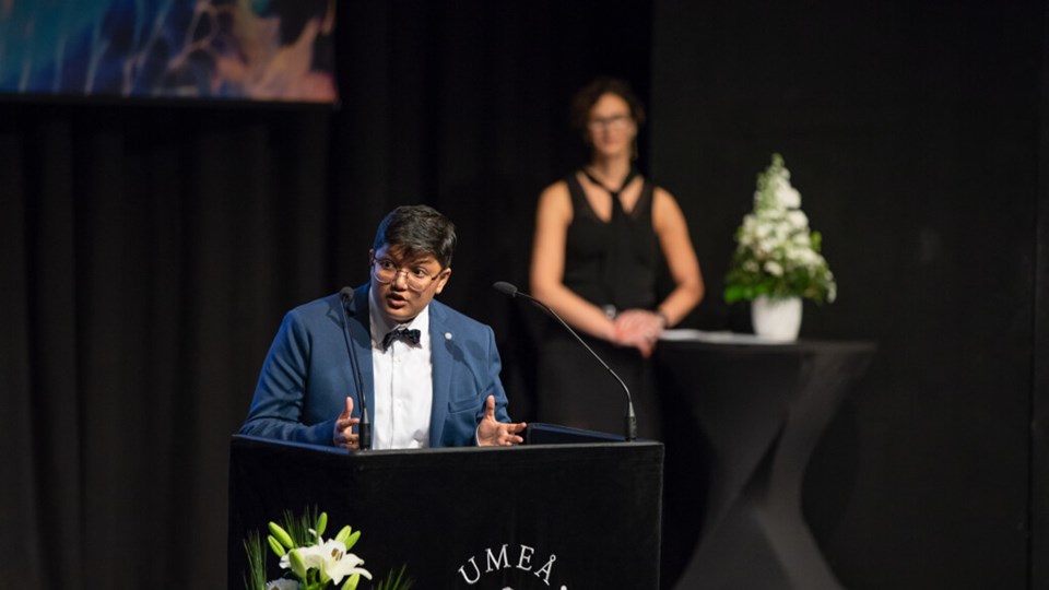 Alumn Kabir Fahria håller tal på scen i Aula Nordica