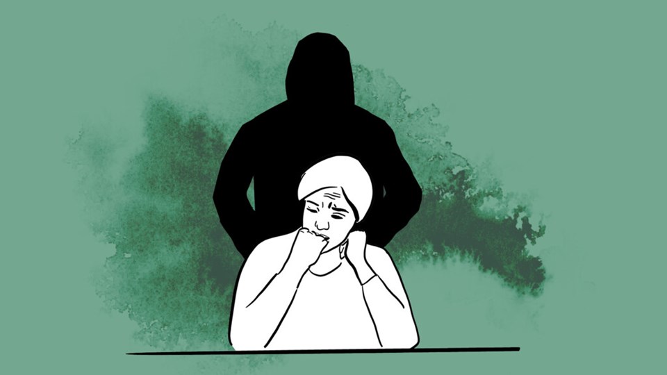 En bekymrad person sitter framför en svart siluett.