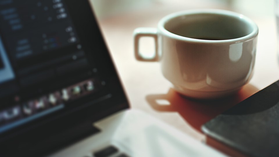 Bild på Kaffekopp, vattenglas och bärbar dator.