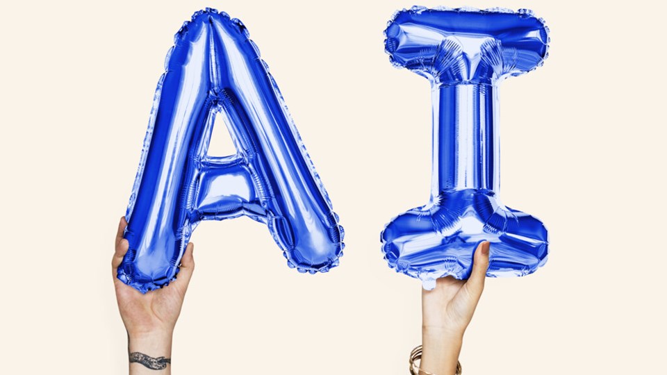Två händer håller upp blå bokstavsballonger med bokstäverna A och I. För at illustrera artificiell intelligens.
