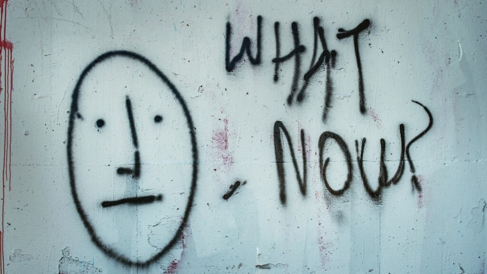 Graffitti på en vägg med texten What now?